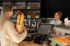 Mittlere Schussfrau, die in der Bäckerei arbeitet service kundenservice abrechnung personal automatisierung team 